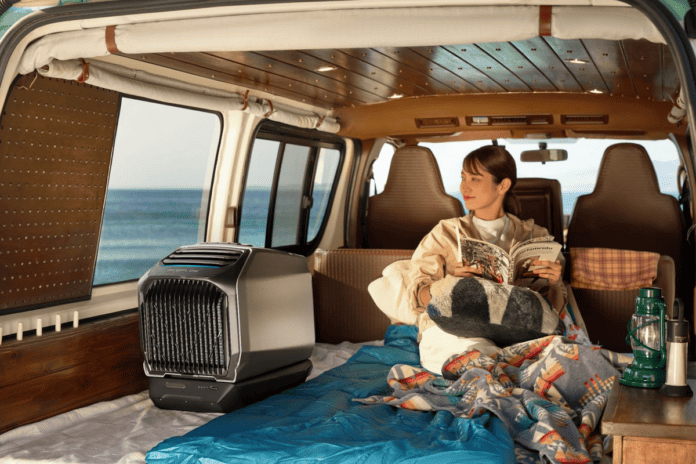 a woman sitting in the back of a van next to an air conditioner